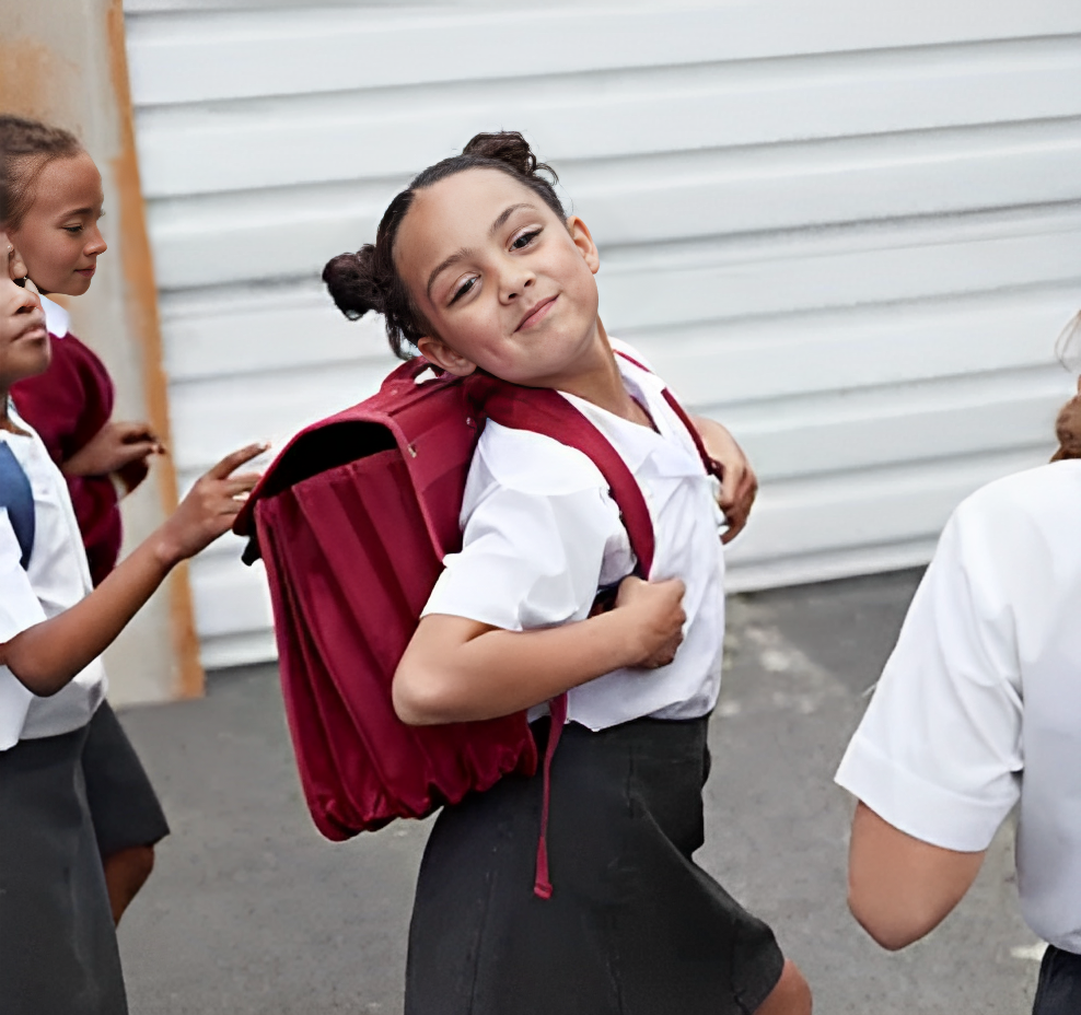 smiling little girl carrying a backpack